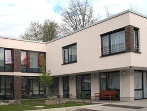 Wohnheim St. Hedwig - Der Ersatzneubau bietet Platz für 24 Bewohner in 3 Wohngruppen. Jede Gruppe verfügt über einen eigenen Koch-Ess-Wohn-Bereich. Durch die feine Baukörpergliederung und die großzügigen Außenanlagen, ergänzt um einen zentralen Aufenthalts- und Therapieraum, bietet das Gebäude seinen Bewohnern eine hohe Wohnqualität.